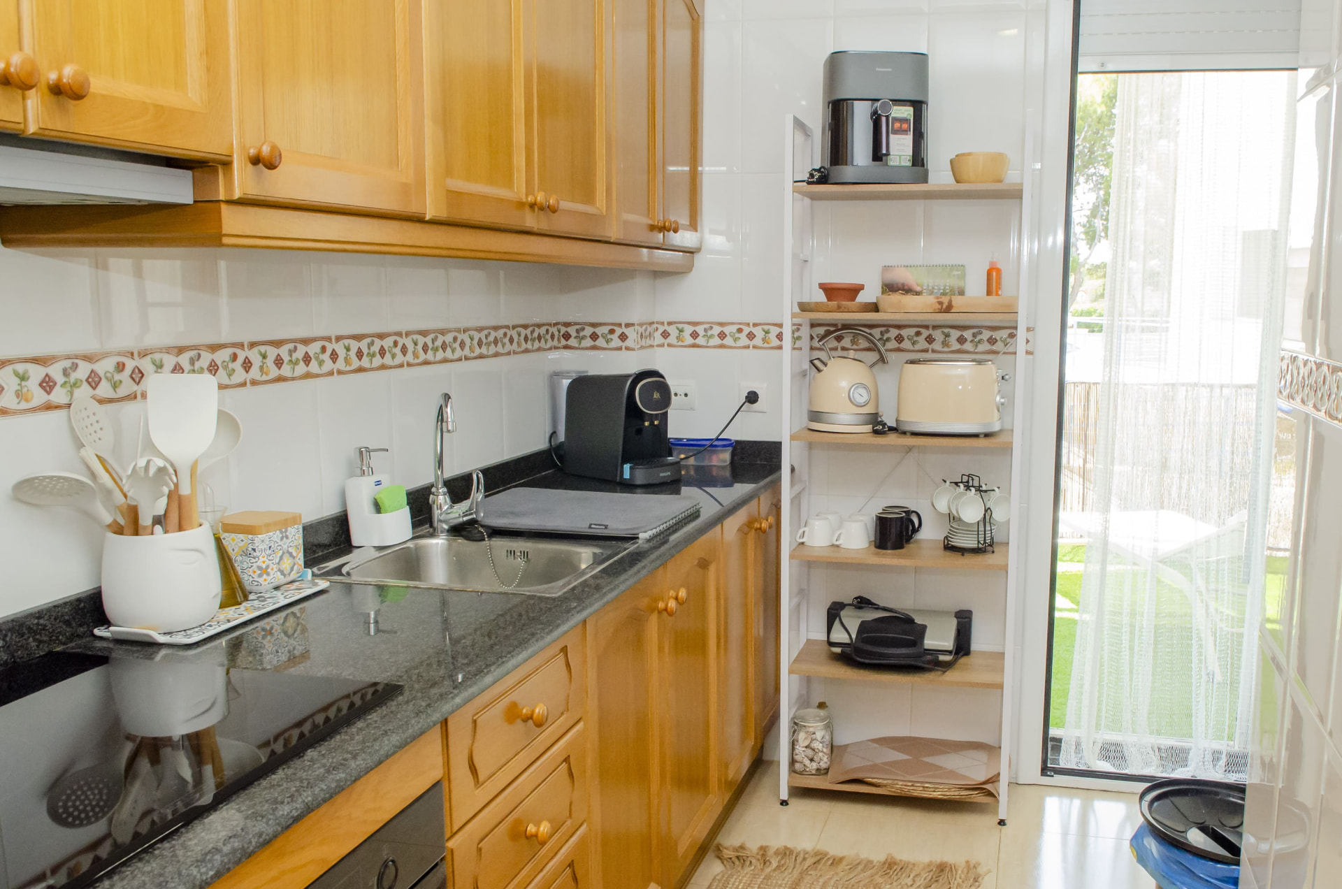Cocina equipada con vitrocerámica, cafetera, hervidor y tostadora