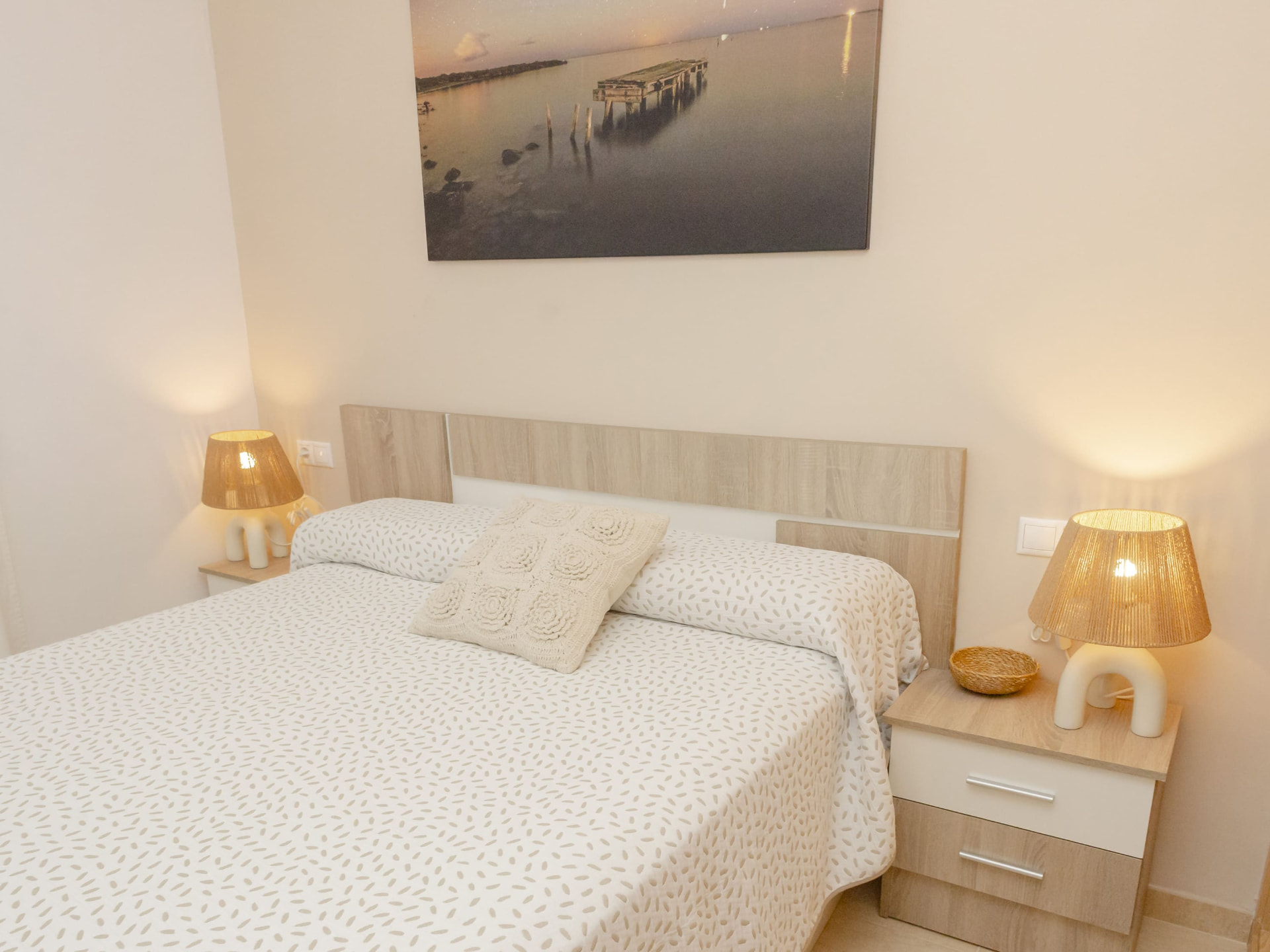 Habitación principal con cama de matrimonio y mesillas de madera